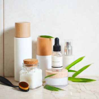 Face cream, serum, lotion, moisturizer and sea salt  among bamboo leaves in the bath